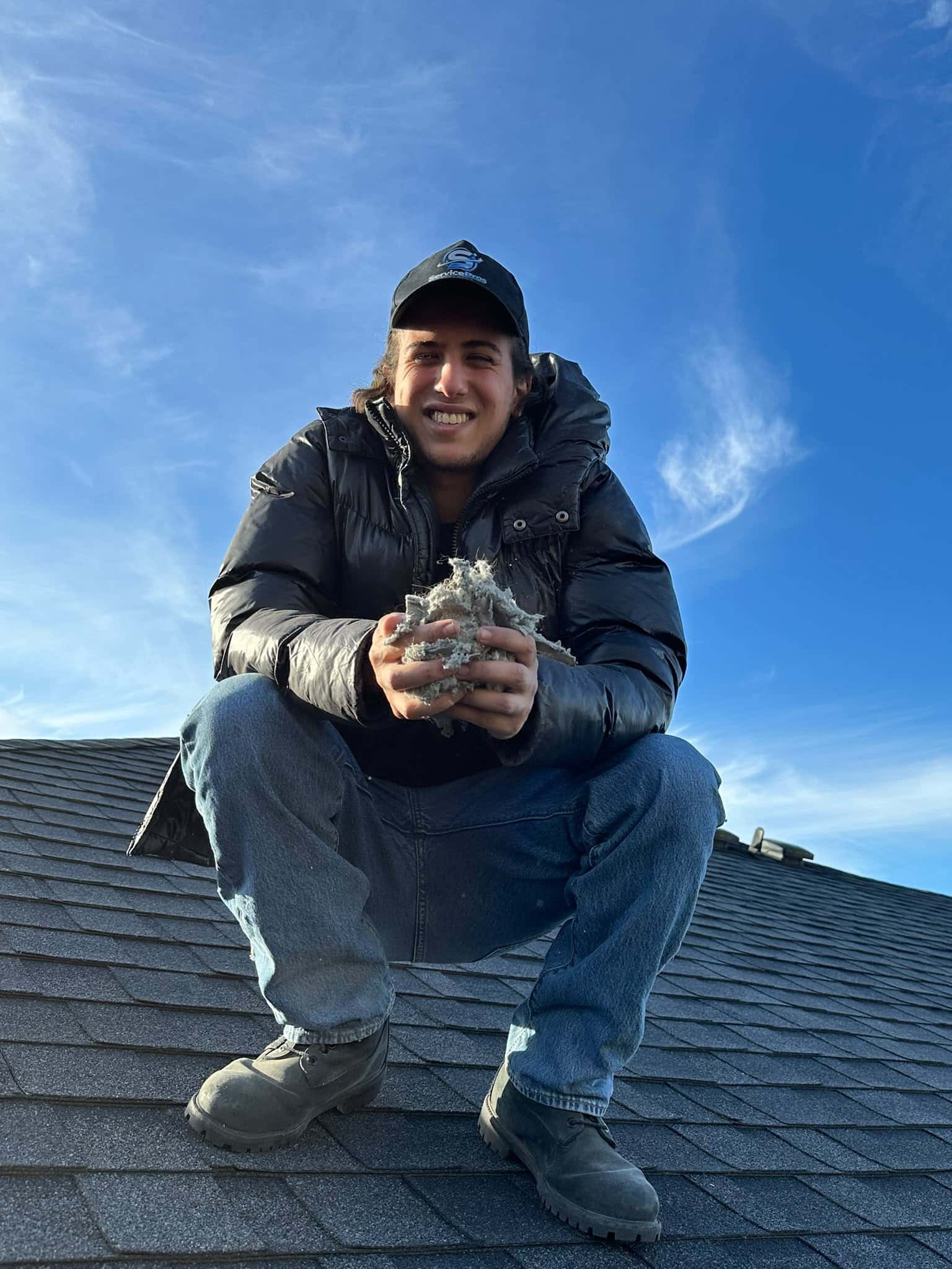 ServicePros technician holding lint removed from a rooftop dryer vent